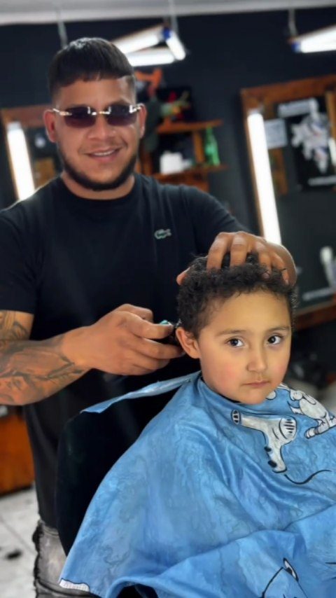 Barbero cortando el pelo a un niño